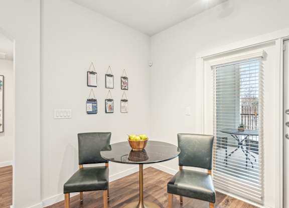 A dining room with a table and two chairs.