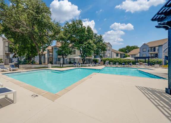 A large swimming pool surrounded by residential buildings.
