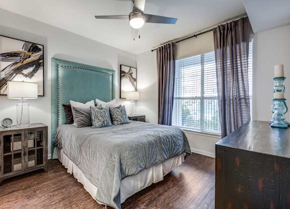 a bedroom with a large bed and a ceiling fan