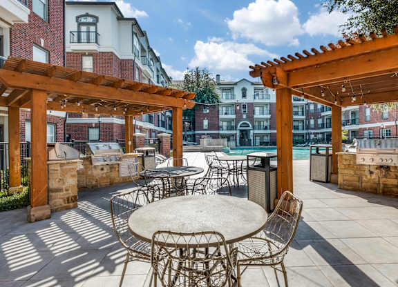 an outdoor patio with tables and chairs and a pool