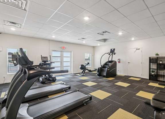 A gym with treadmills, elliptical machines, and other exercise equipment.