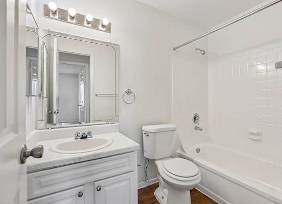 A white bathroom with a sink, toilet, and bathtub.