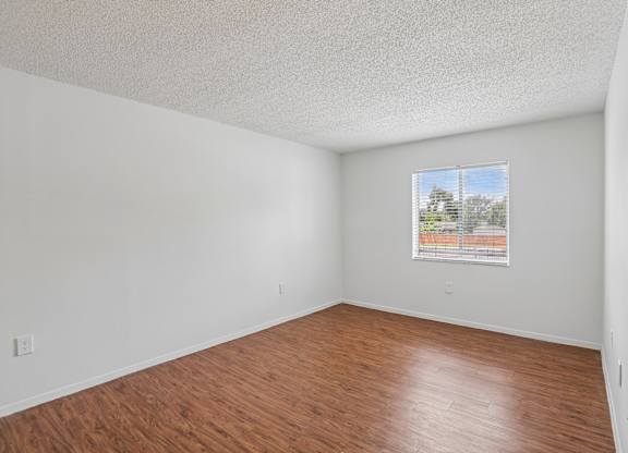 Empty room with wooden floor and a window.