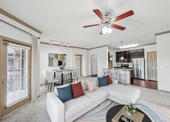 A living room with a white couch and a ceiling fan.