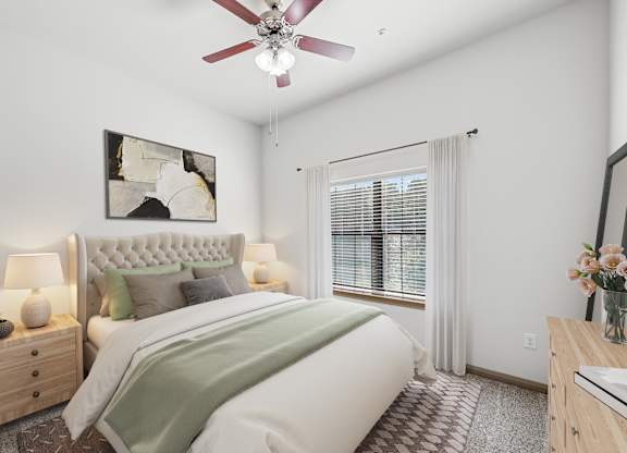 A bedroom with a large bed, a ceiling fan, and a painting on the wall.