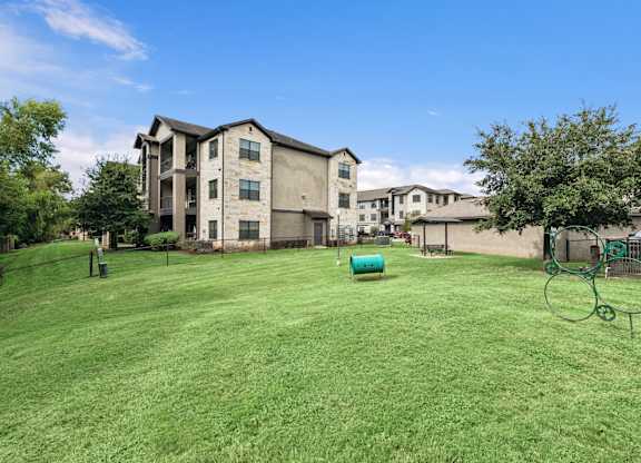 A large grassy area in front of apartment buildings.