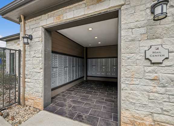 A mail center is located in a stone building with a large, open door.