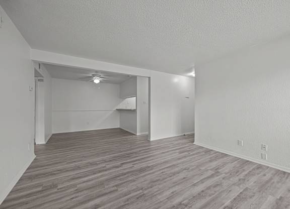 A room with wooden flooring and white walls.