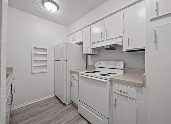 A kitchen with white appliances and cabinets.