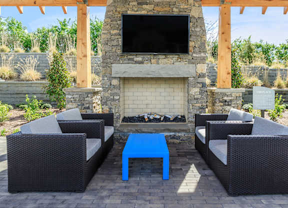 A patio with a fireplace and seating area.