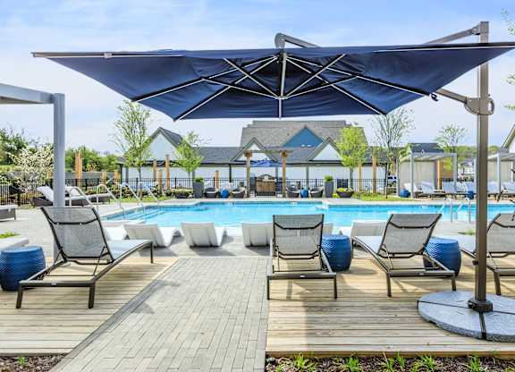 A pool area with a canopy and lounge chairs.