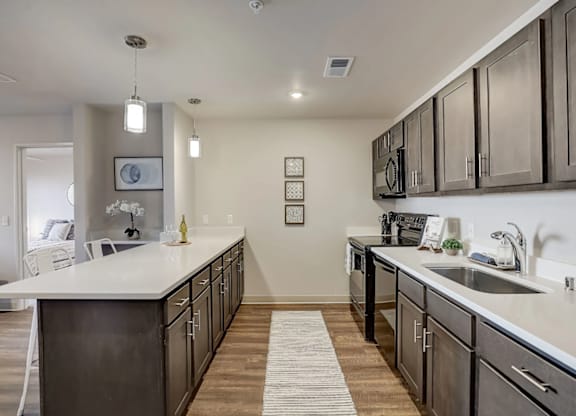 A modern kitchen with dark wood cabinets and white countertops.