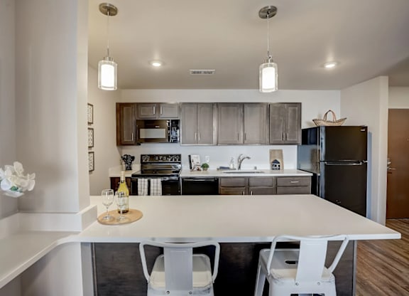 A modern kitchen with a white island and stainless steel appliances.