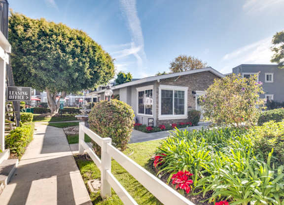 A sunny day in a residential area with a house and a garden.