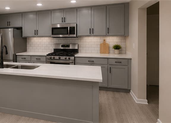 A kitchen with a white countertop and grey cabinets.