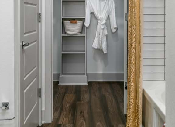 A white bathroom with a white towel hanging on a rack.