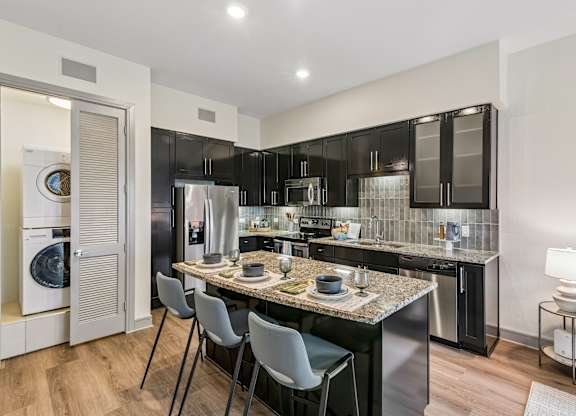 A modern kitchen with a dining table and chairs.