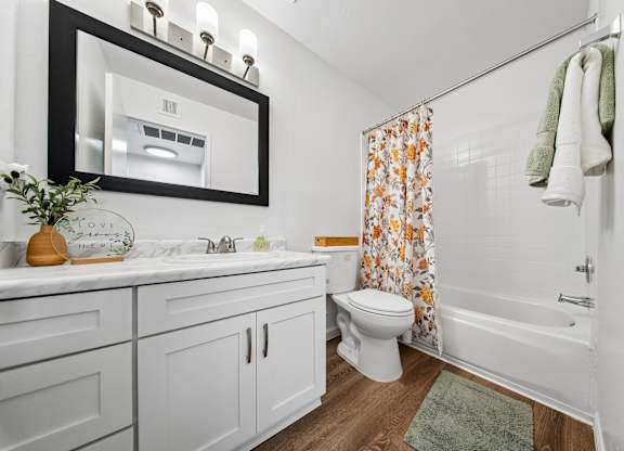 A white bathroom with a toilet, sink, and shower.