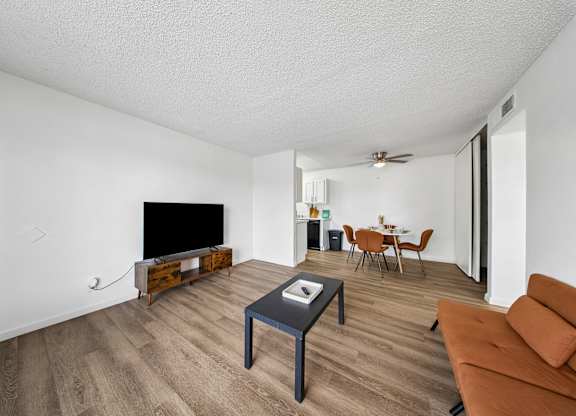 A living room with a brown couch and a black coffee table.