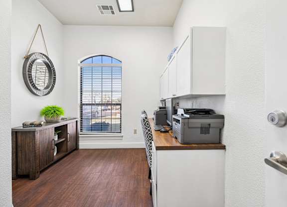 A room with a window, a desk, and a printer.