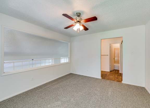 an empty living room with a ceiling fan