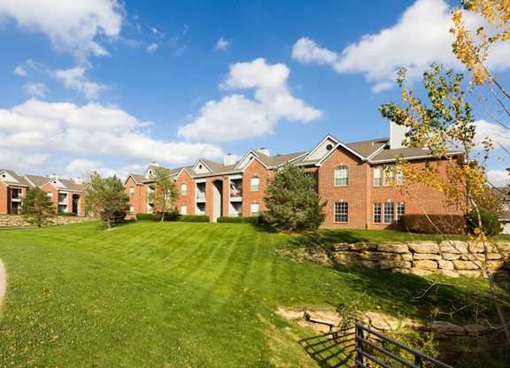 A row of houses with a green lawn in front.