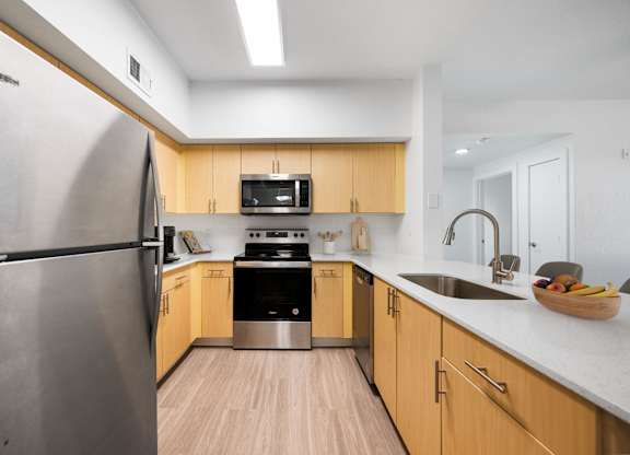 A modern kitchen with wooden cabinets and stainless steel appliances.