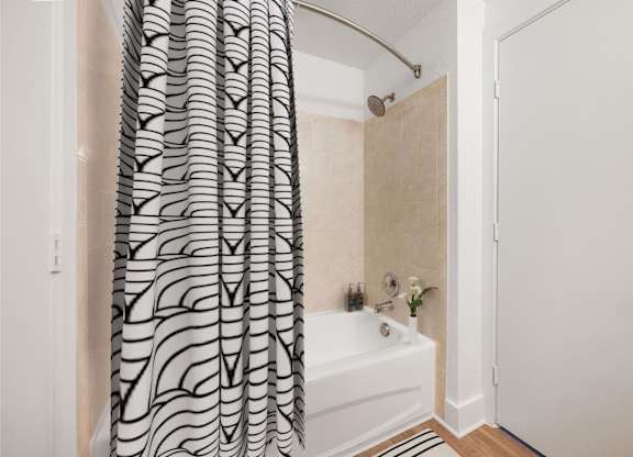 A bathroom with a shower curtain and a white bathtub.