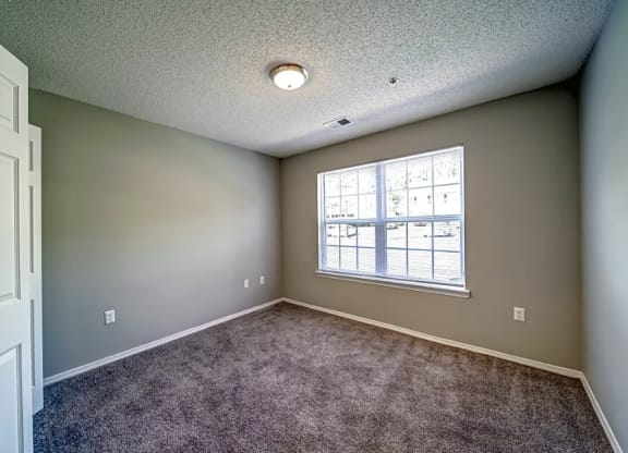 an empty room with carpet and a window