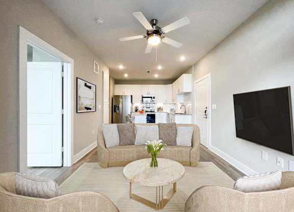 A living room with a beige couch, a coffee table, and a ceiling fan.