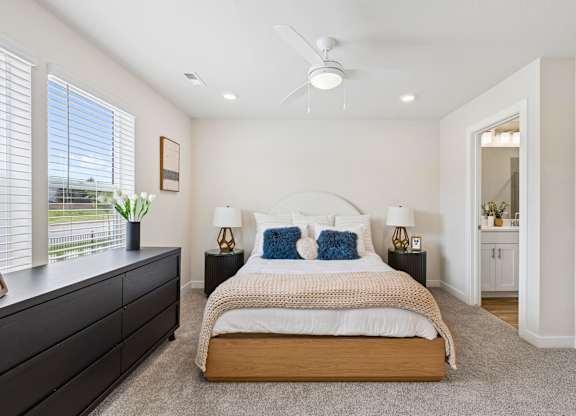 A bedroom with a bed, nightstands, and a window.