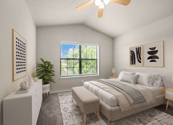 A bedroom with a large bed and a ceiling fan.