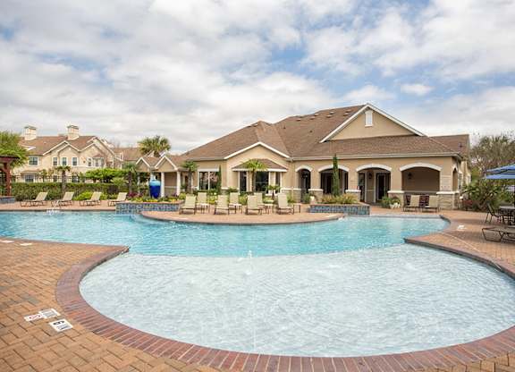 A large swimming pool in front of a house.