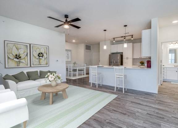 an open living room and kitchen with a ceiling fan
