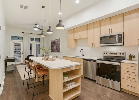 A modern kitchen with wooden cabinets and stainless steel appliances.