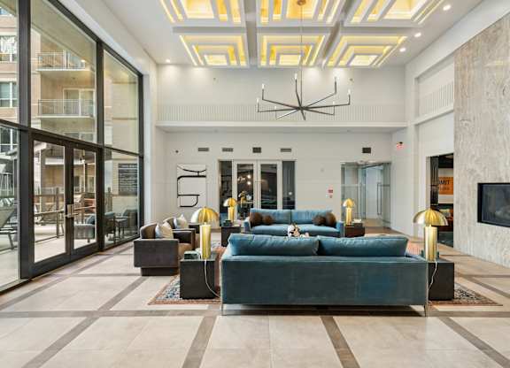A large room with a long couch and a chandelier hanging from the ceiling.