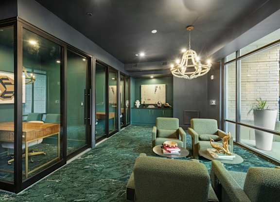 A room with a green carpet and a chandelier hanging from the ceiling.