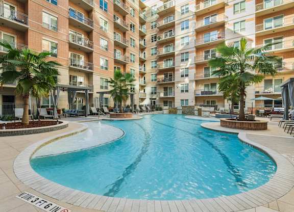 A large outdoor swimming pool surrounded by apartment buildings.