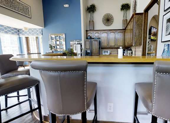 Two grey bar stools are placed in front of a bar.