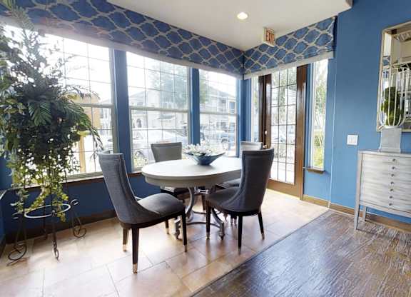A dining room with a table and chairs.
