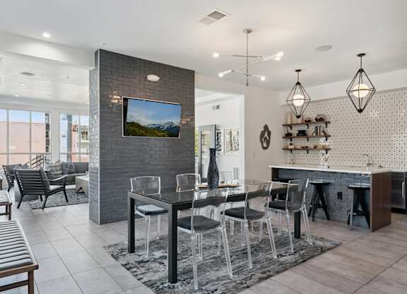 A modern dining room with a glass table and chairs.