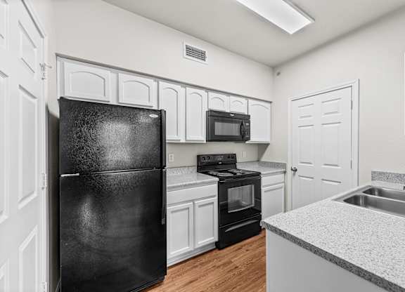 the preserve at ballantyne commons apartment kitchen with black appliances and white cabinets