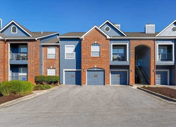 A row of red brick houses with blue garage doors.