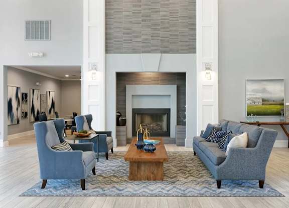 A living room with a fireplace and a grey couch.