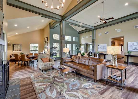 A living room with a brown couch and a rug.