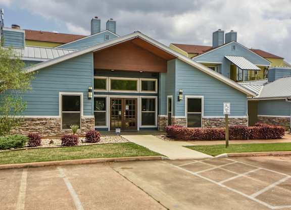 A blue building with a stone foundation and a large glass door.