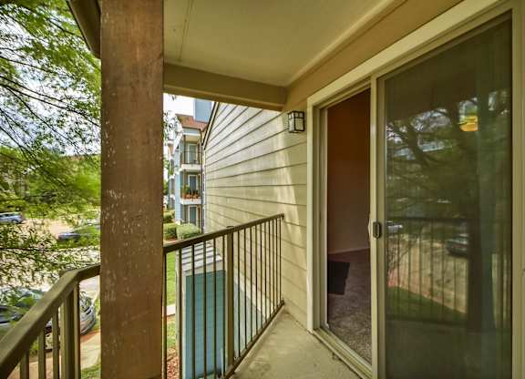 A balcony with a glass door and a metal railing.
