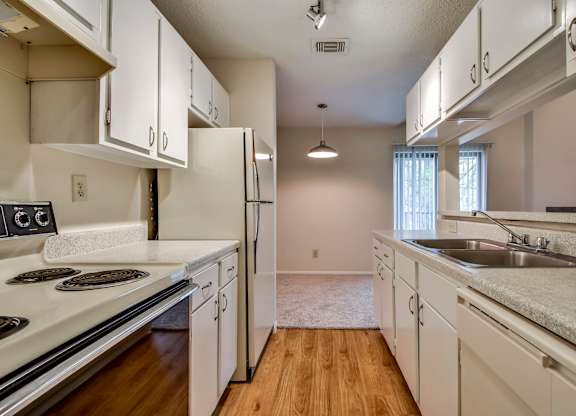 A kitchen with white cabinets and a stove top oven.