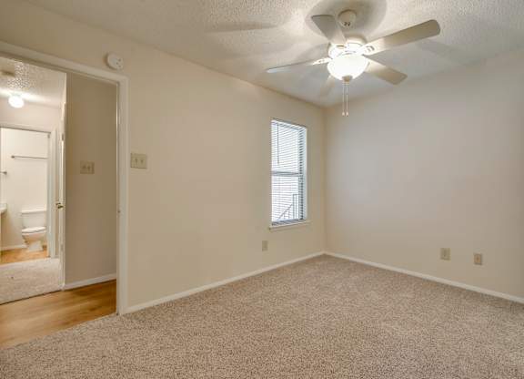 A room with a ceiling fan and a window.