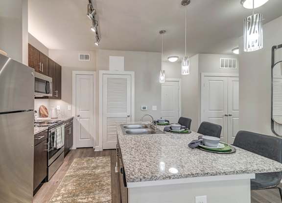 A kitchen with a granite countertop and a refrigerator.